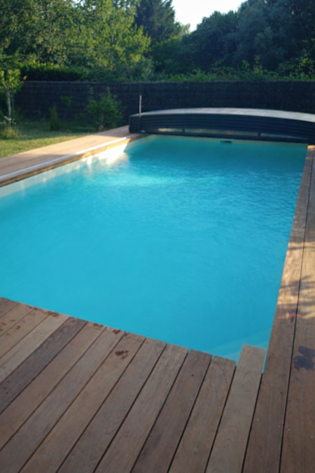 Piscine rénovée avec terrasse bois et volet roulant intégré