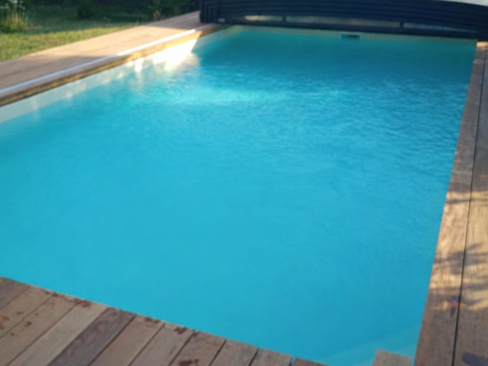 Piscine rénovée avec terrasse bois et volet roulant intégré
