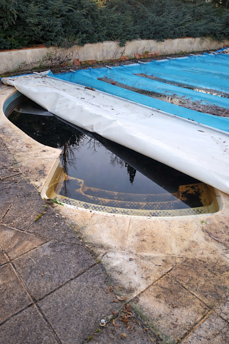 Piscine avant rénovation avec couverture dégradée