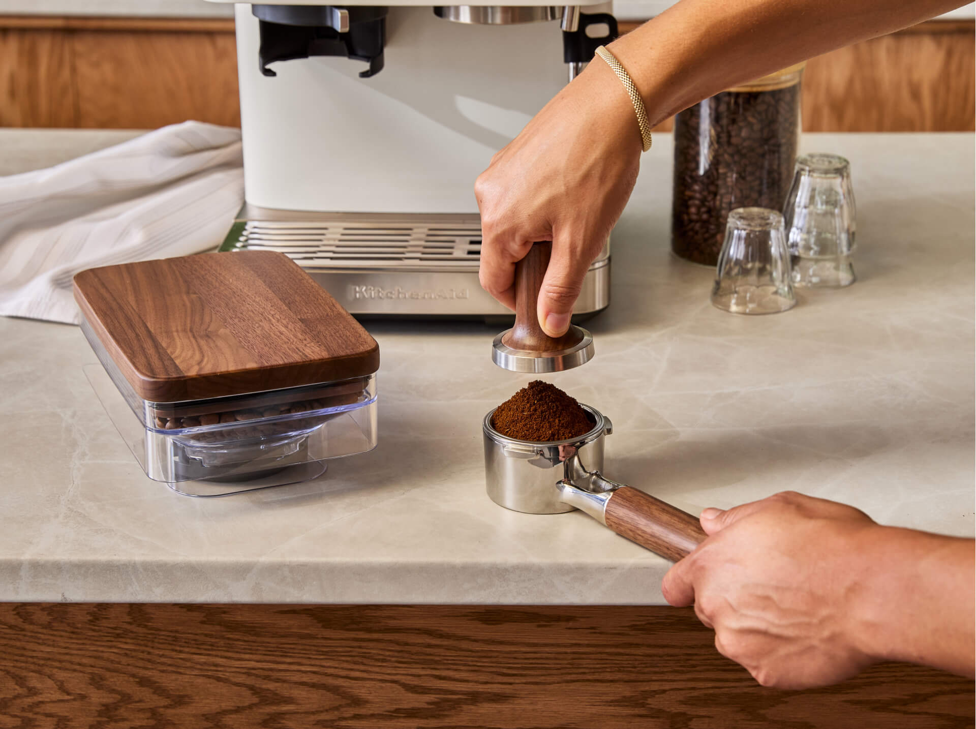 A person tamping down the espresso grounds.