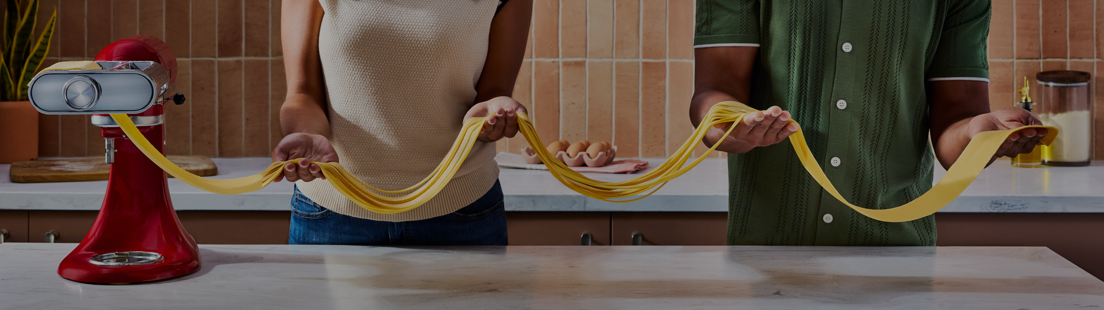People rolling dough with the 3-in-1 pasta attachment. 