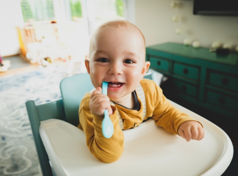 baby-with-a-spoon-in-a-chair