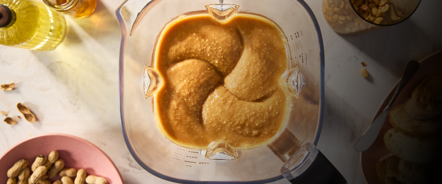 Overhead shot of a KitchenAid® blender with creamy peanut butter inside.