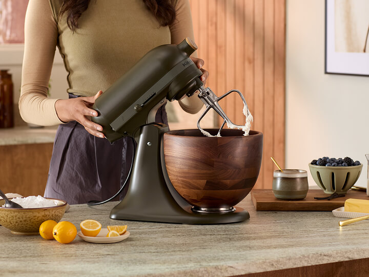 A person using a KitchenAid® stand mixer in Evergreen