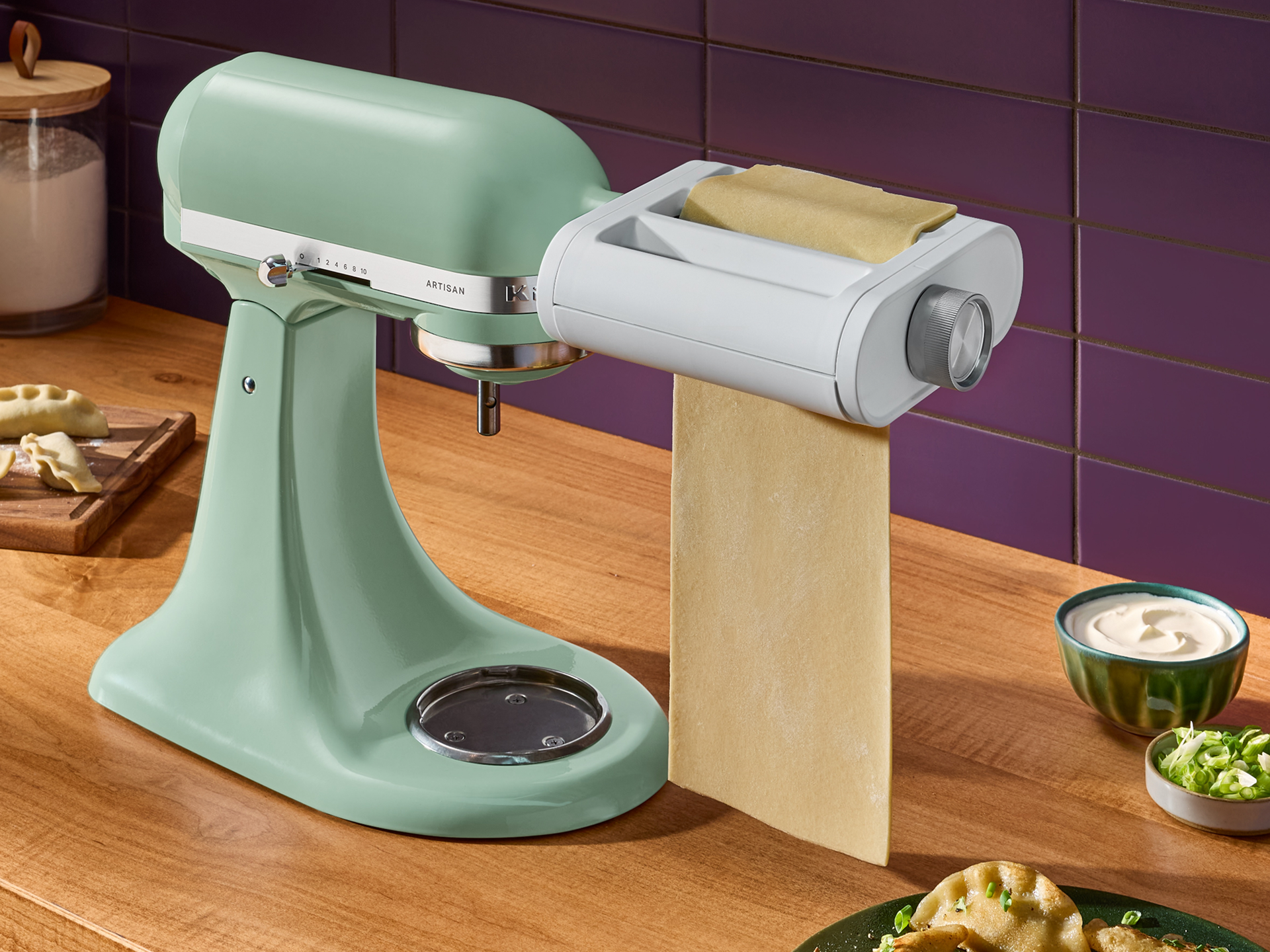 A KitchenAid® stand mixer rolling dough with the 3-in-1 pasta attachment. 