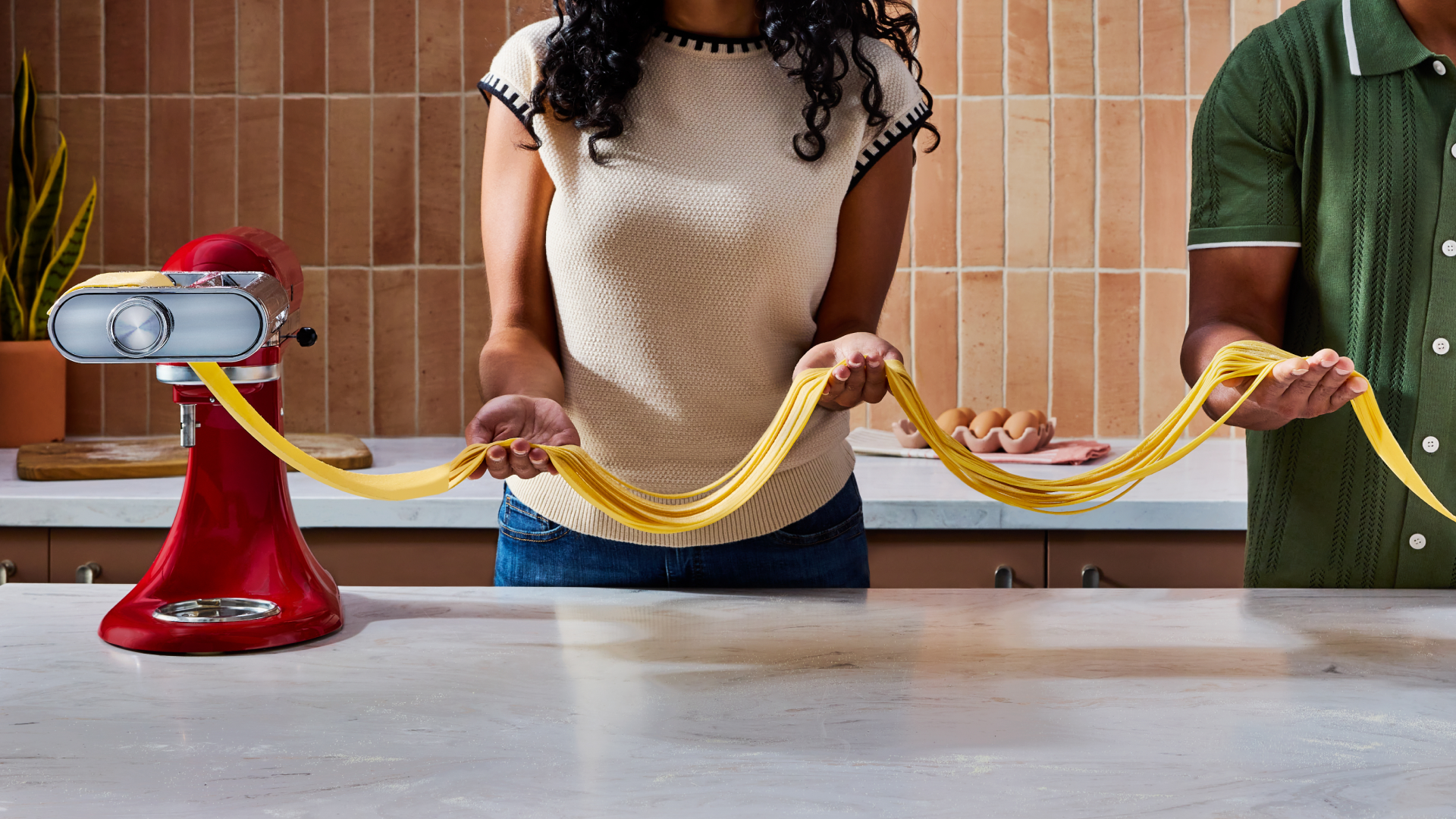 People rolling dough with the 3-in-1 pasta attachment. 