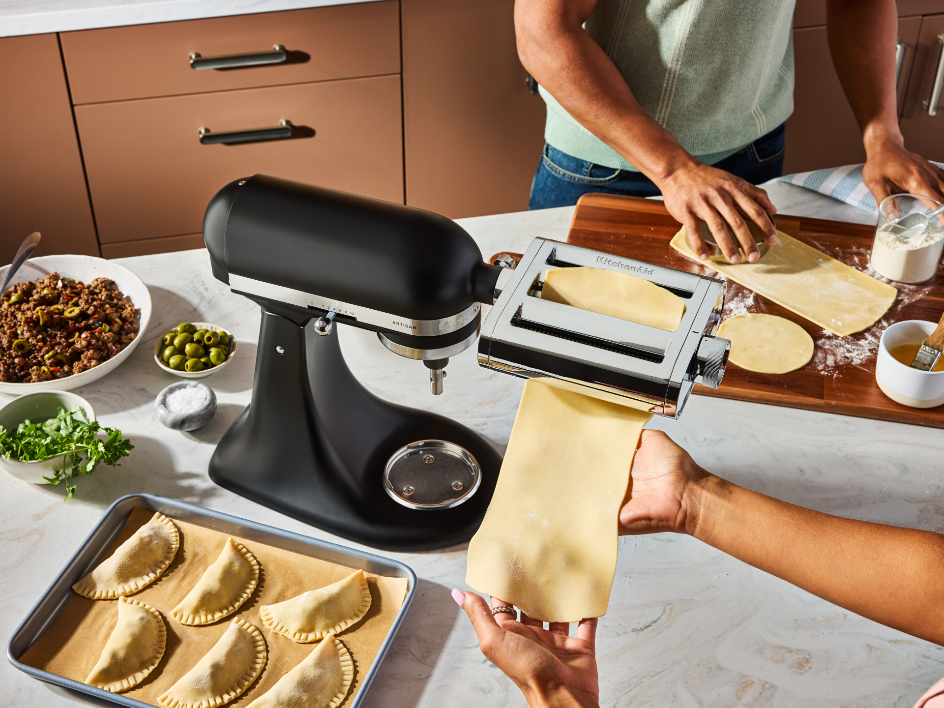 People rolling dough with the 3-in-1 metal pasta attachment.