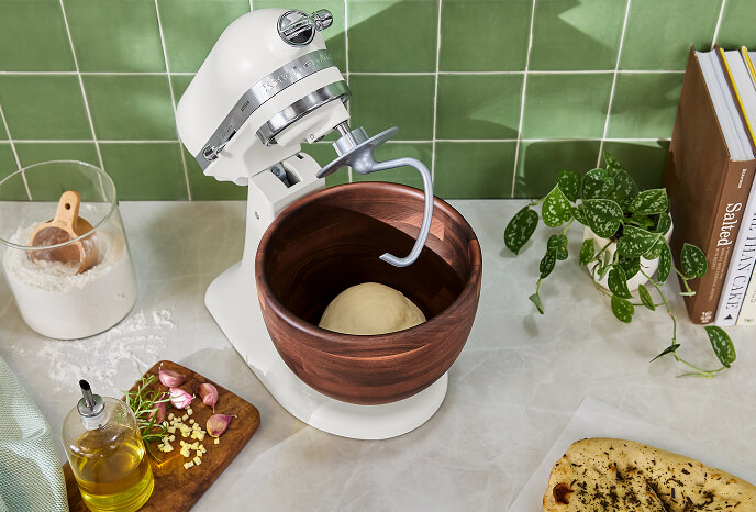 A KitchenAid®️ Stand Mixer in Porcelain White, surrounded by pastries