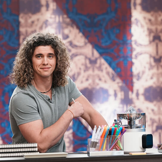 A person standing next to a KitchenAid® juicer