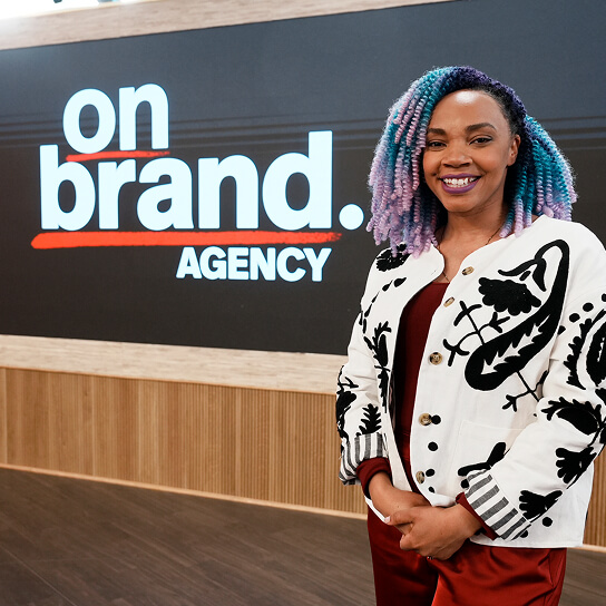 A person standing in front of the On Brand backdrop