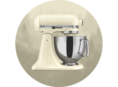 An Almond Cream stand mixer on a foggy background with fir trees.