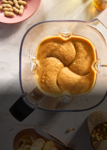 Overhead shot of a KitchenAid® blender with creamy peanut butter inside.