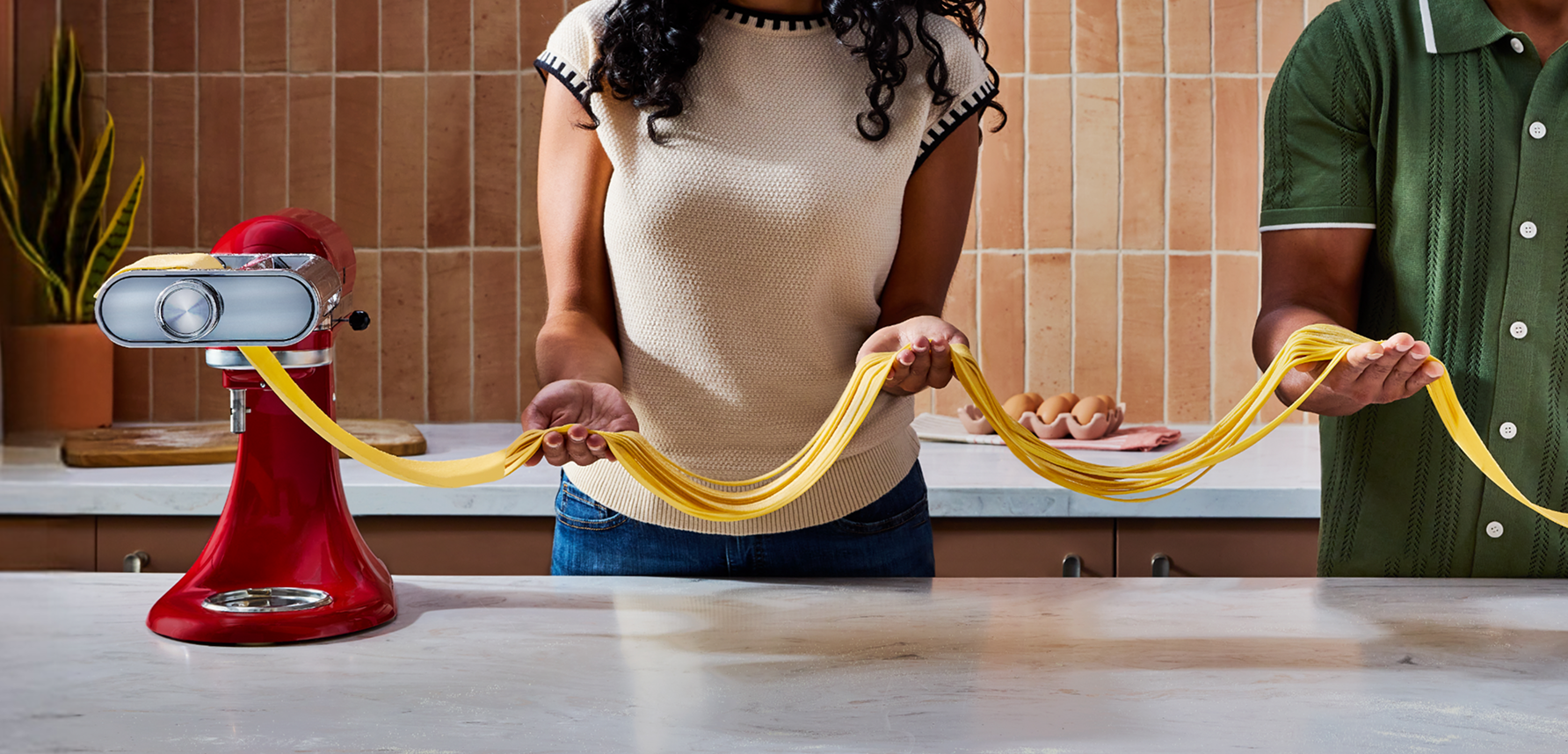 Two images showing a KitchenAid® stand mixer using the 3-in-1 pasta attachment. 