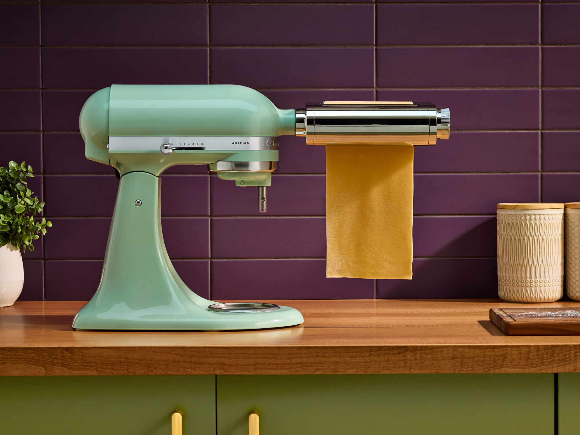 A KitchenAid® stand mixer rolling dough with the 3-in-1 metal pasta attachment. 