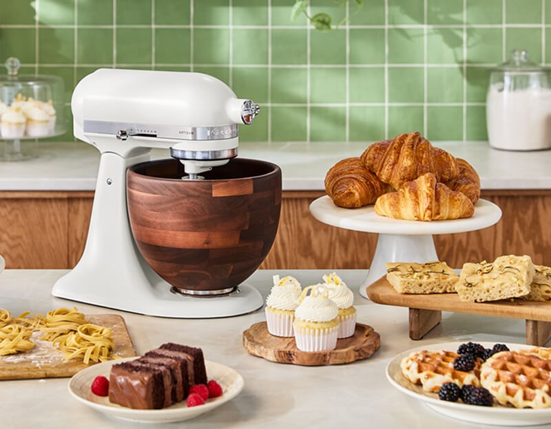 A Porcelain KitchenAid® Stand Mixer surrounded by various baked goods.