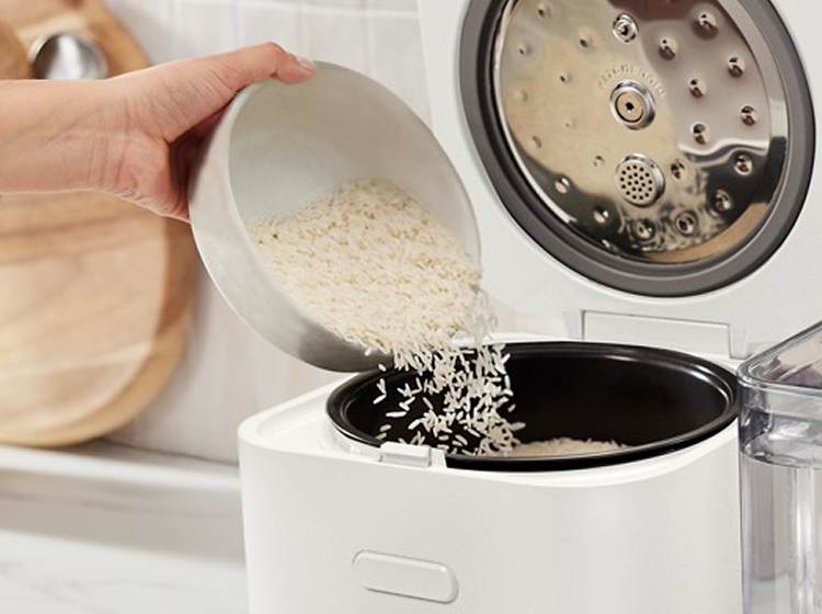 Broth being poured into the grain and rice cooker.