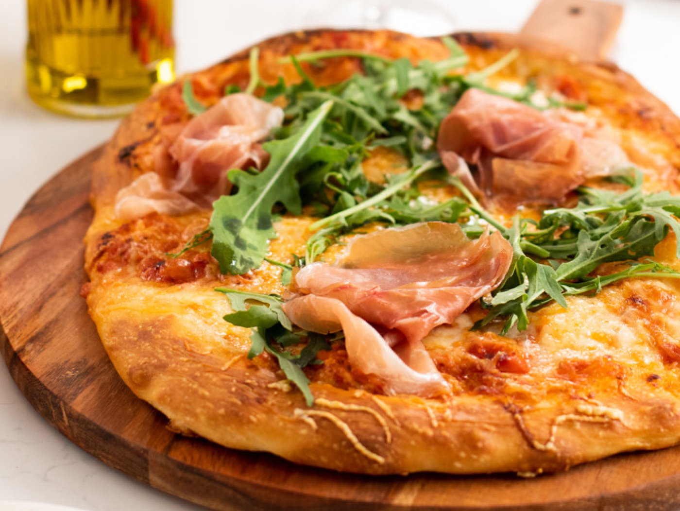 Pizza made with prosciutto and arugula.