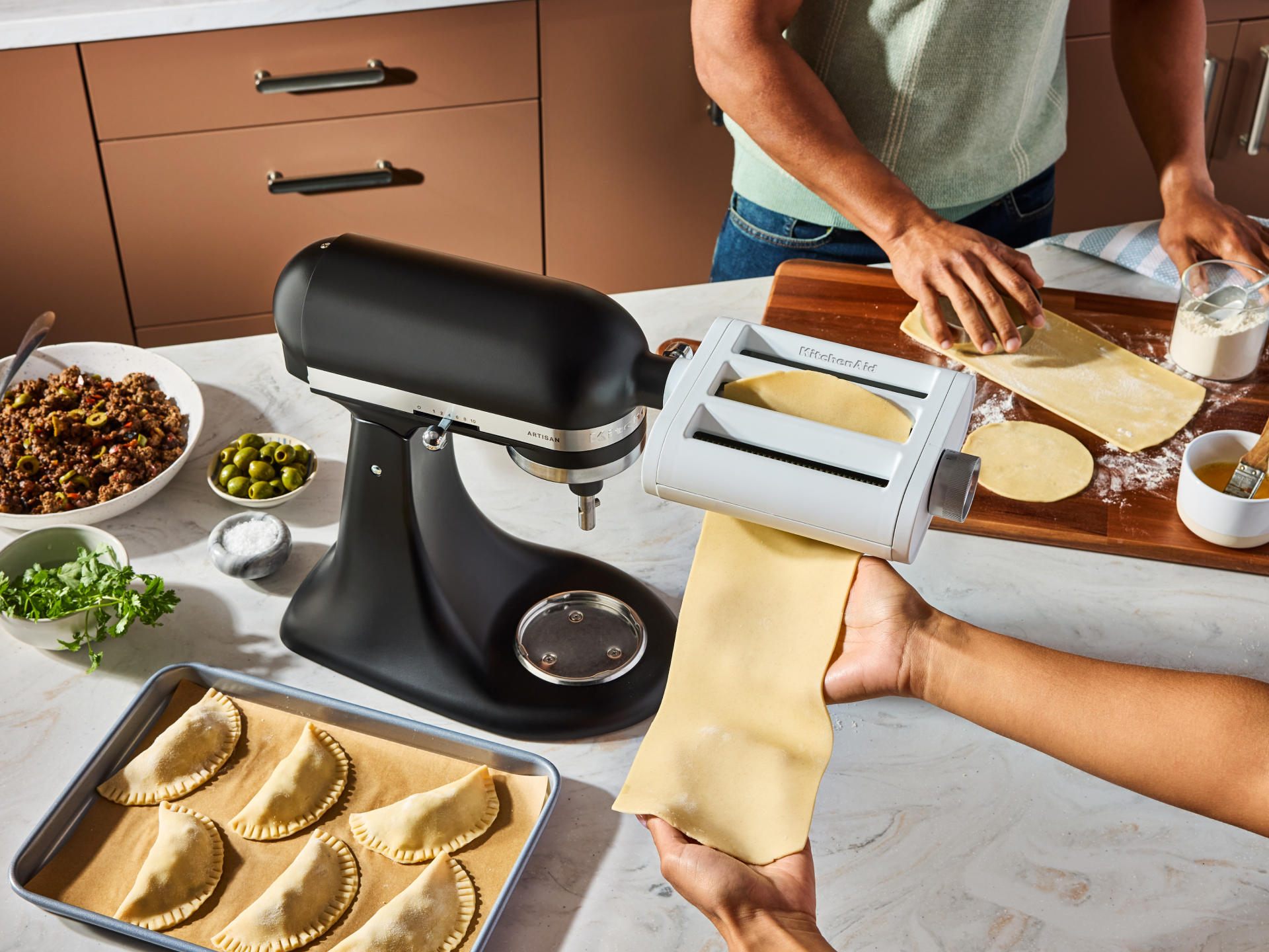 People rolling dough with the 3-in-1 pasta attachment.