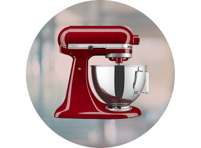 An Empire Red stand mixer on a patterned gray-blue background.