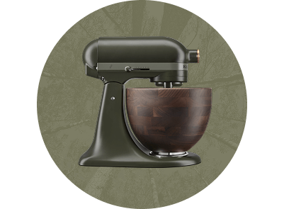 An Evergreen stand mixer on a forest green background with a leaf motif.