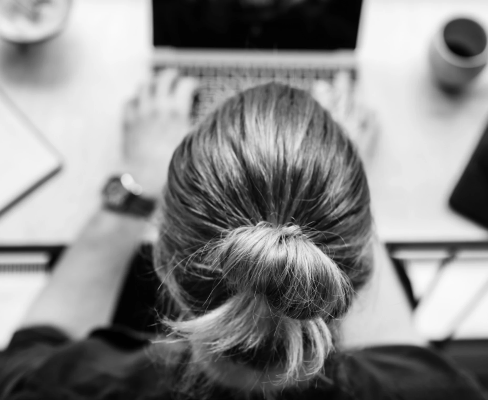 Schwarz-Weiß-Bild einer Frau, die am Laptop arbeitet.