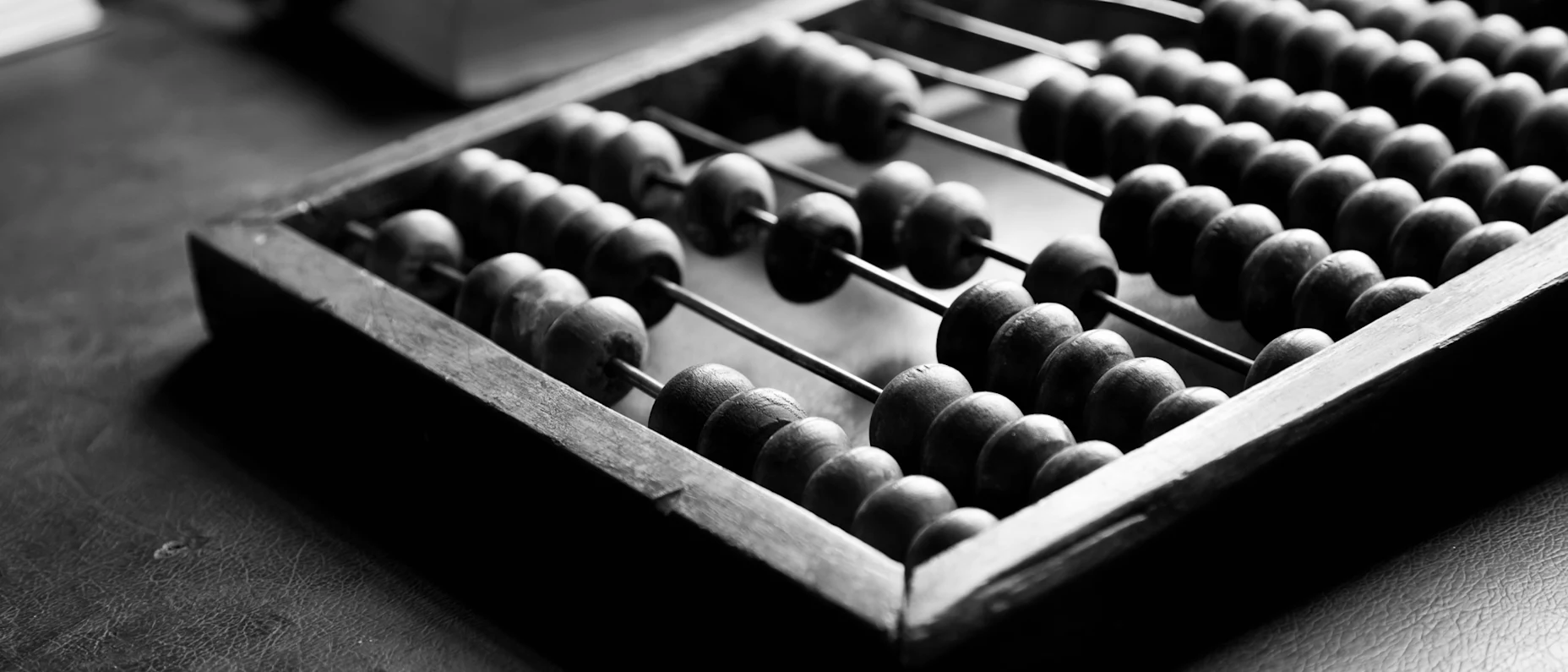 Schwarz-Weiß-Bild einer Abakus-Rechentafel.