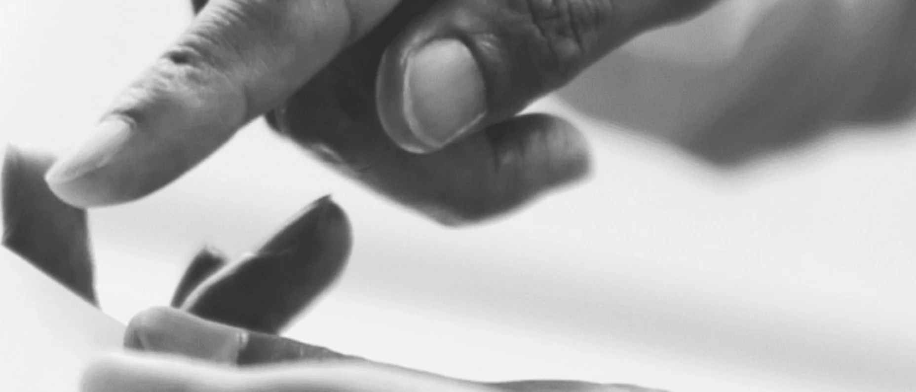 Schwarz-Weiß-Bild von einer Hand, die auf ein Tablet zeigt.