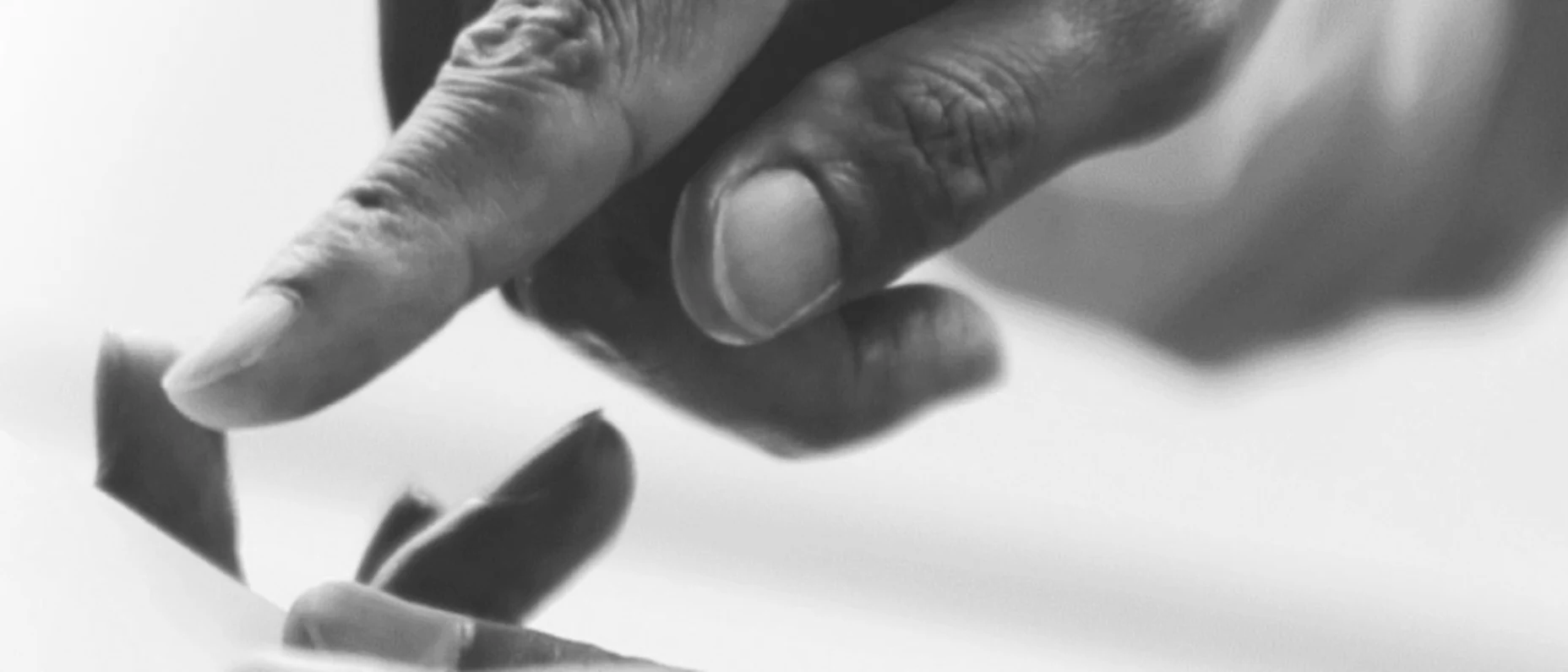 Schwarz-Weiß-Bild von einer Hand, die auf ein Tablet zeigt.