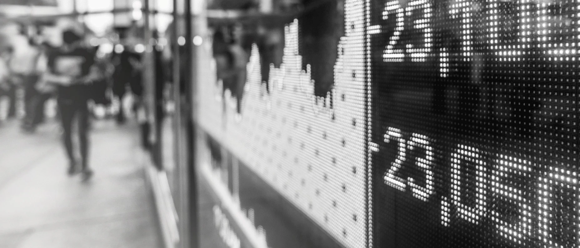 Schwarz-Weiß-Bild eines Displays mit Börsenkursen.