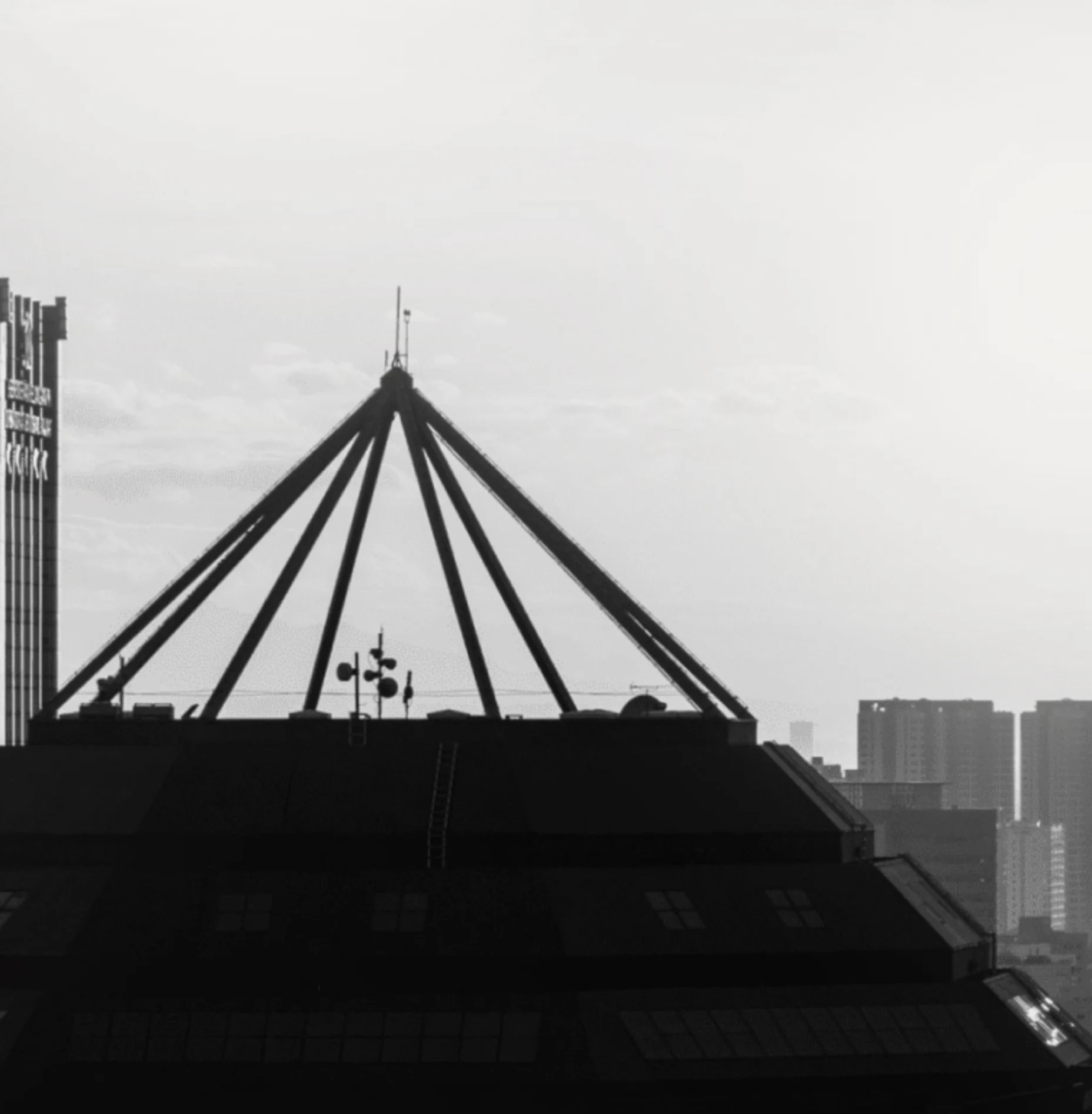 Schwarz-Weiß-Bild von Hochhausdächern im Nebel.