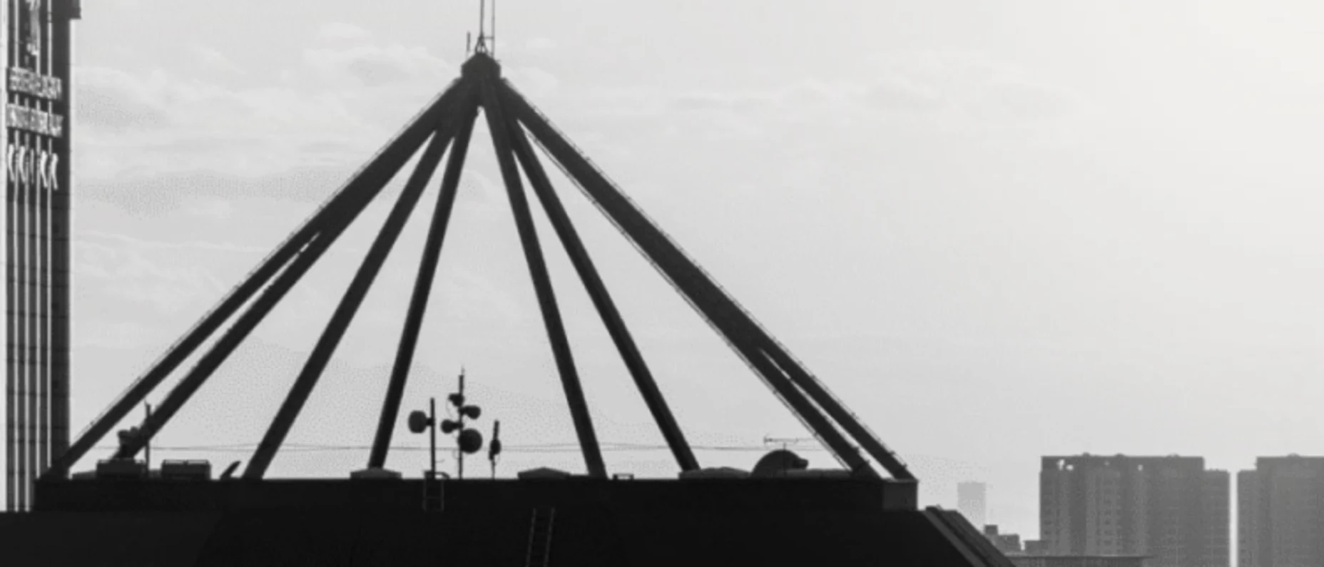 Schwarz-Weiß-Bild von Hochhausdächern im Nebel.