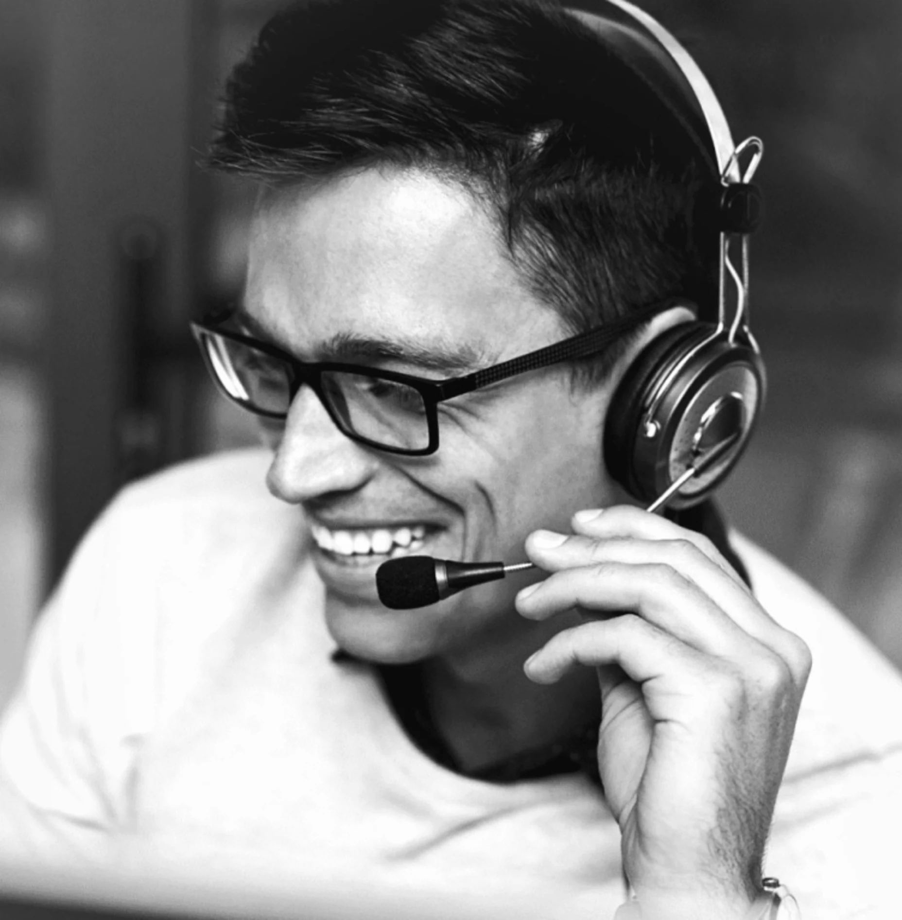 Schwarz-Weiß-Bild von einem am Headset sprechenden Mann.