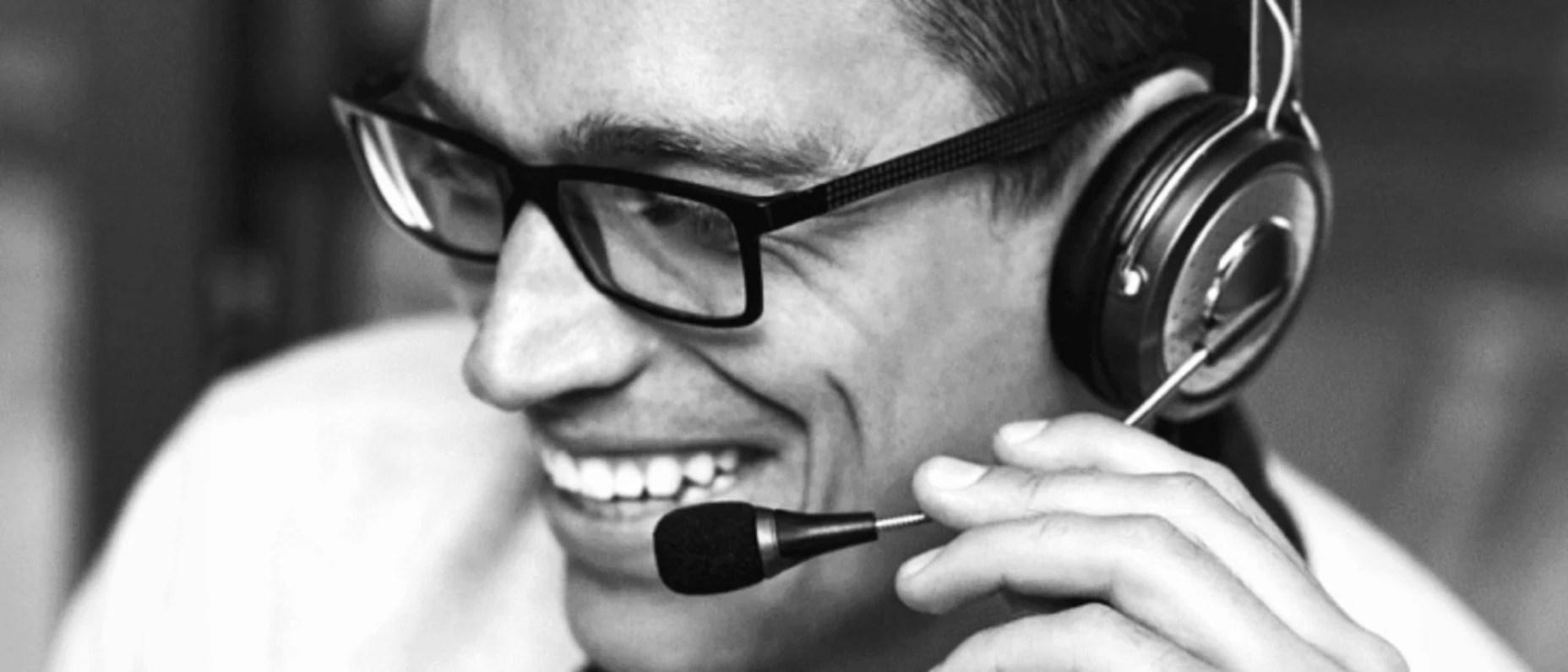 Schwarz-Weiß-Bild von einem am Headset sprechenden Mann.