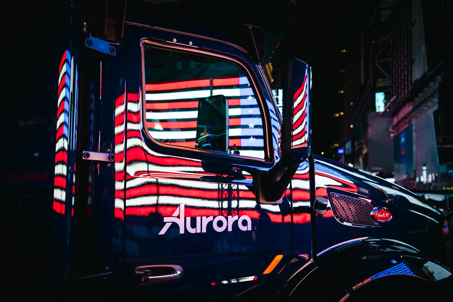Aurora truck at night with reflection of the US flag