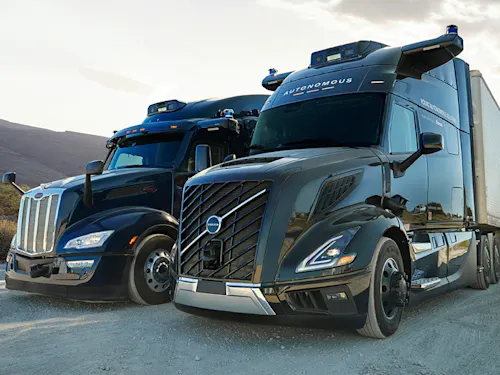 Two Aurora trucks parked in a desert landscape