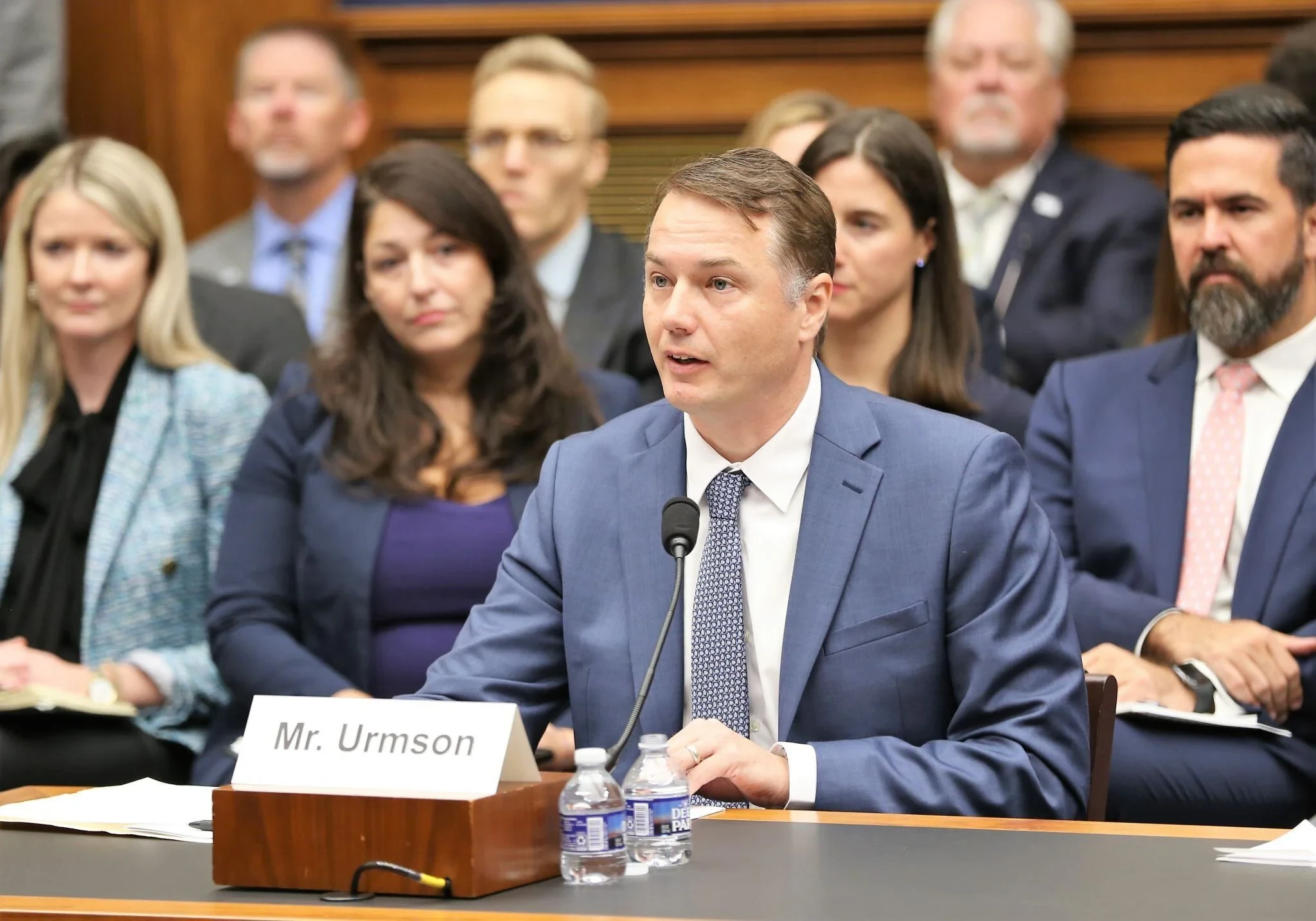 Chris Urmson seated and speaking in front of the US House of Representatives
