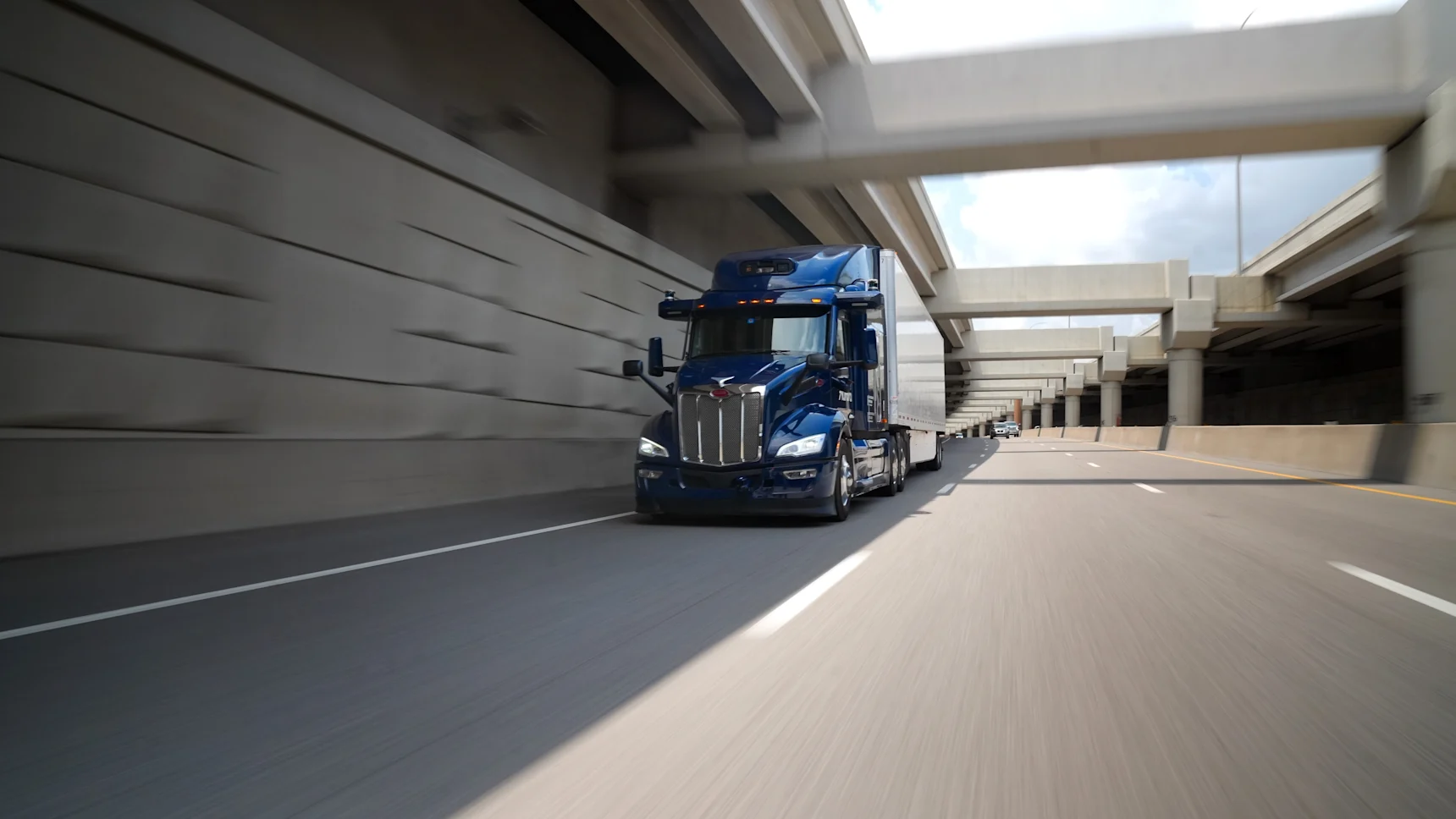 Aurora truck driving down a urban highway