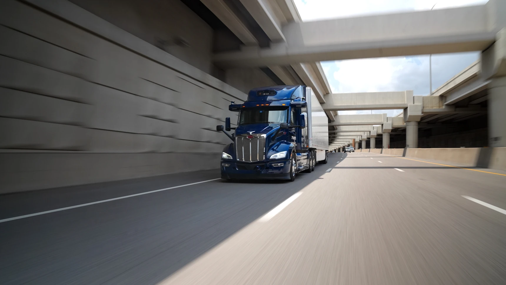 Aurora truck driving down a urban highway