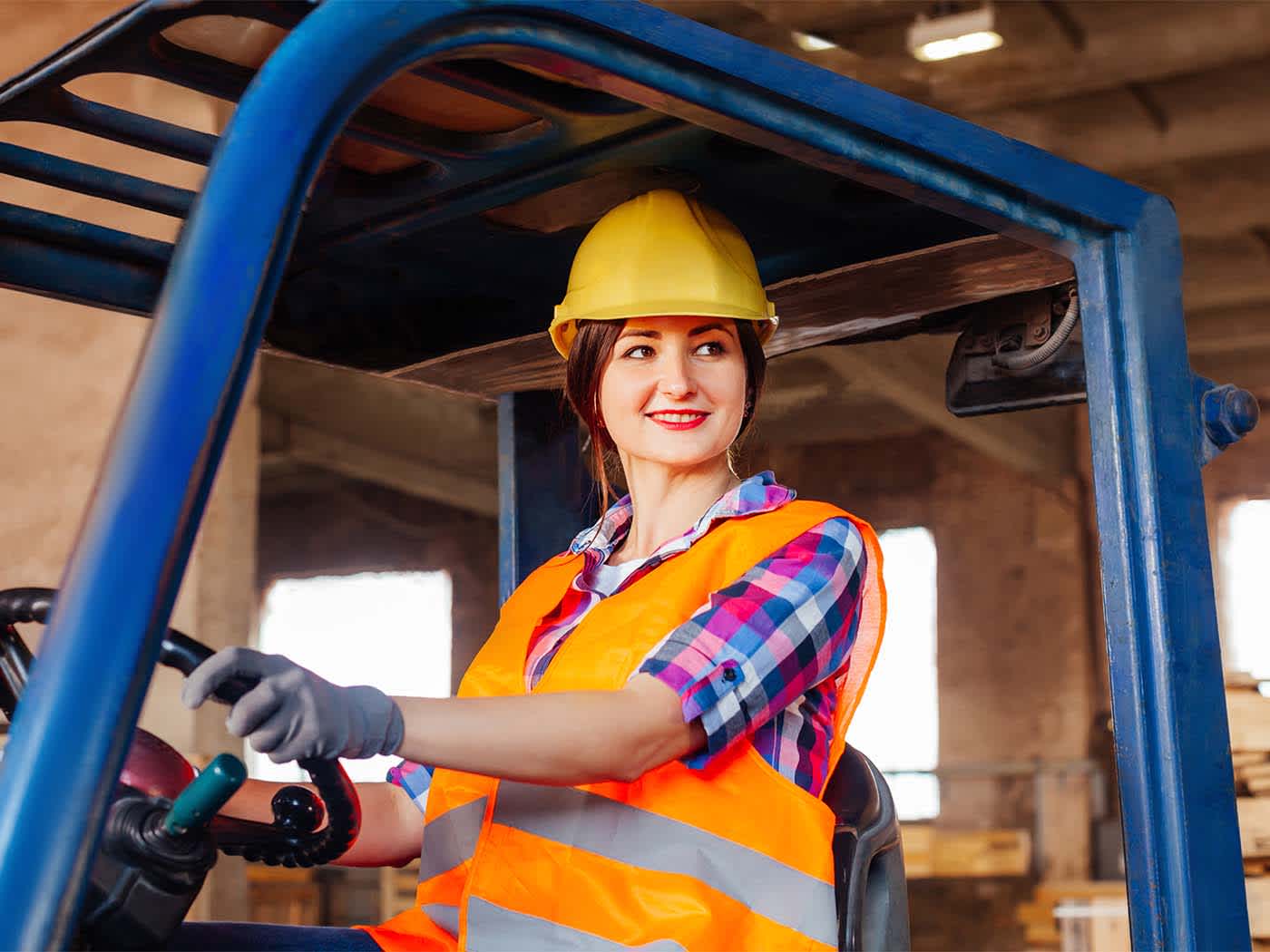 Young woman driving a forklift truck.