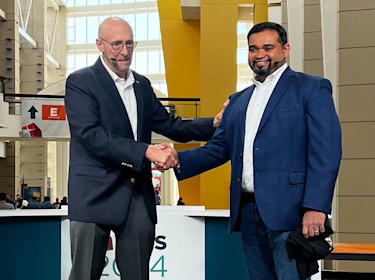 Joe Gopi (right), director of manufacturing at Sumitomo Drive Technologies, receives the 2024 National Metalworking Reshoring Award from Harry Moser, founder and president of the Reshoring Initiative, on the IMTS+ Main Stage at IMTS 2024 in Chicago. Sumitomo was recognized for its success in bringing manufacturing to the United States through foreign direct investment and to Mexico via nearshoring. 