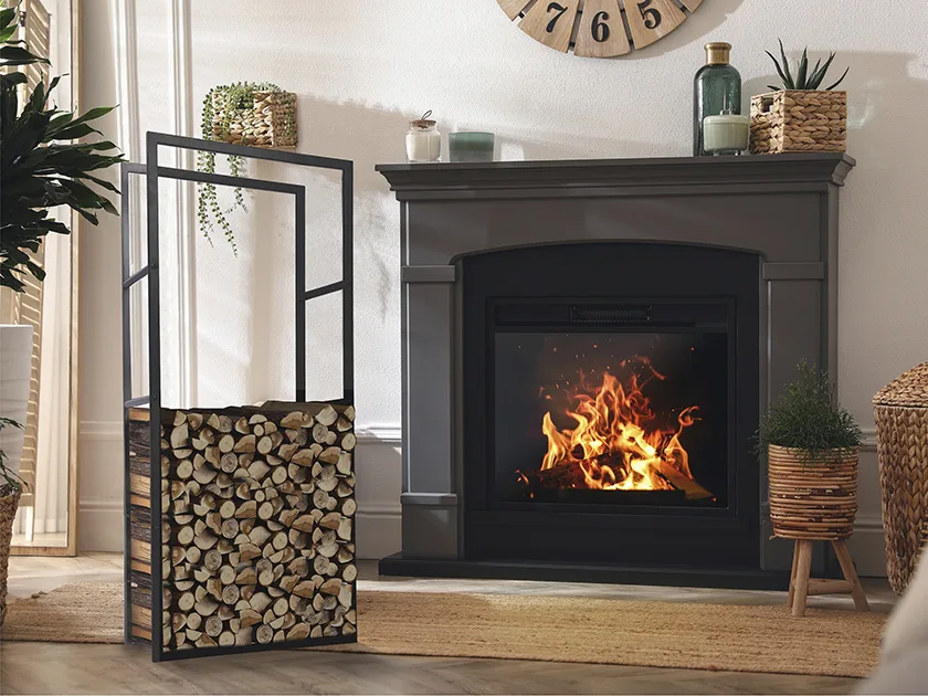 Puolillaan täynnä oleva korkea takkapuuteline mustan takan edessä