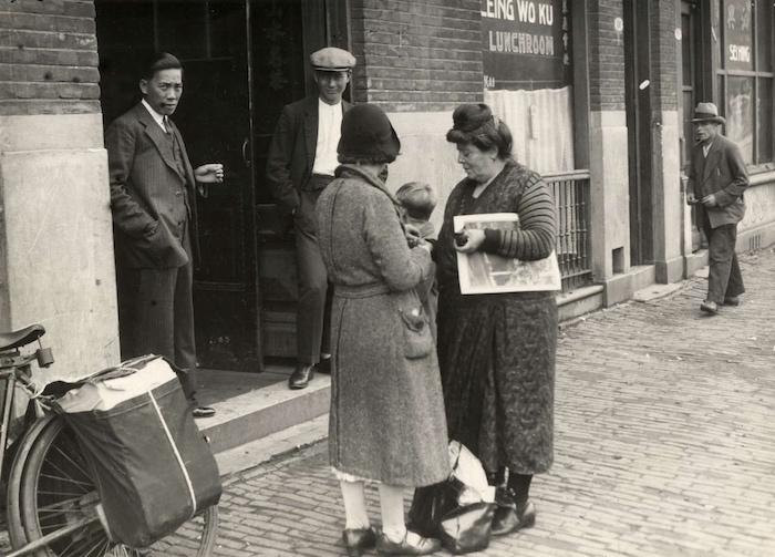 Chinese restaurants en lunchrooms in de wijk Katendrecht, Rotterdam, Nederland 1932. De Chinese eigenaar staat in de deuropening kopie