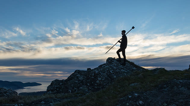 Surveyor standing on a hill with a trimble R12i antenna