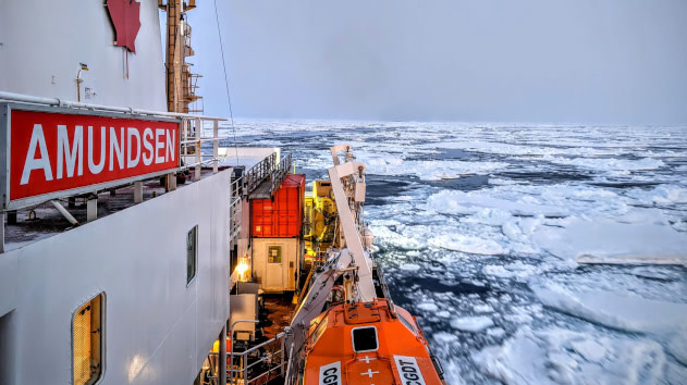 Surveying boat moving through sheets of ice in the Canadian arctic