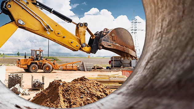 Excavator moving dirt from the viewpoint of a pipe