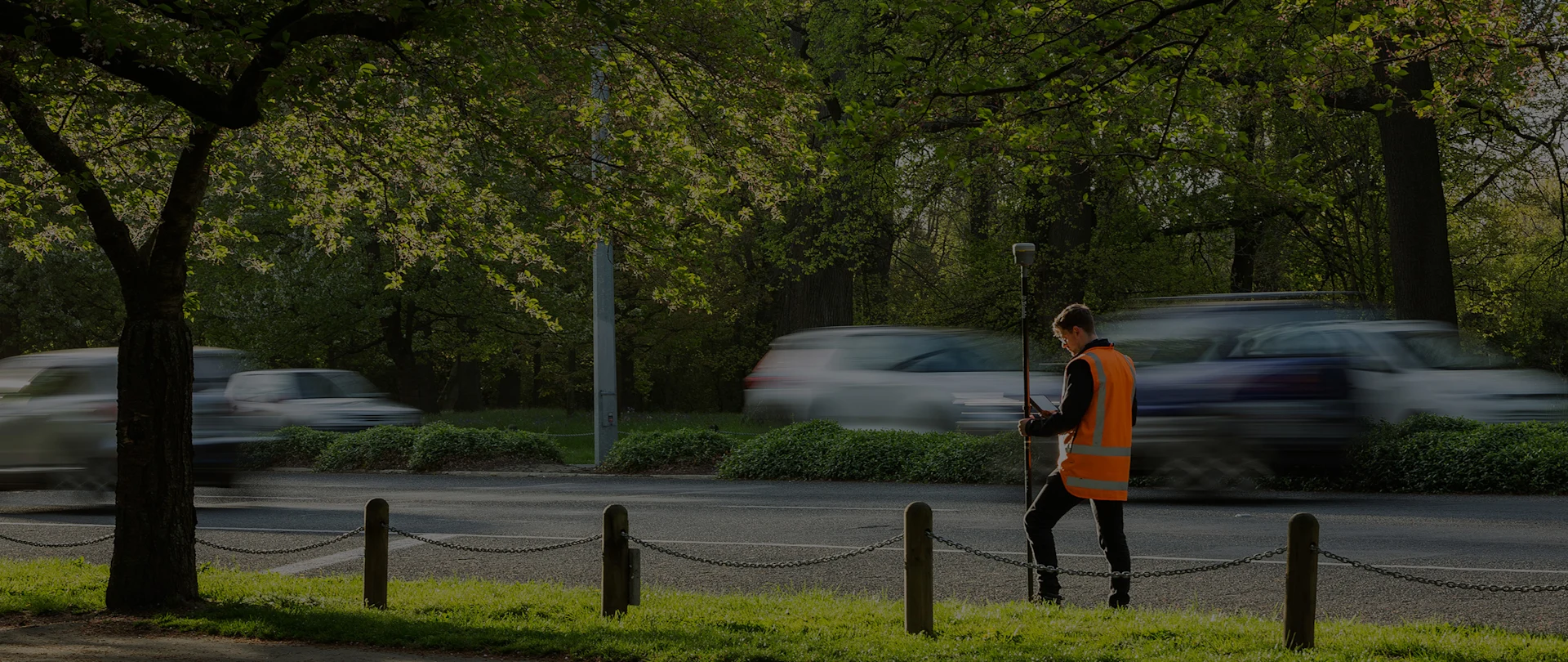 Surveyor on a roadside holding a trimble antenna