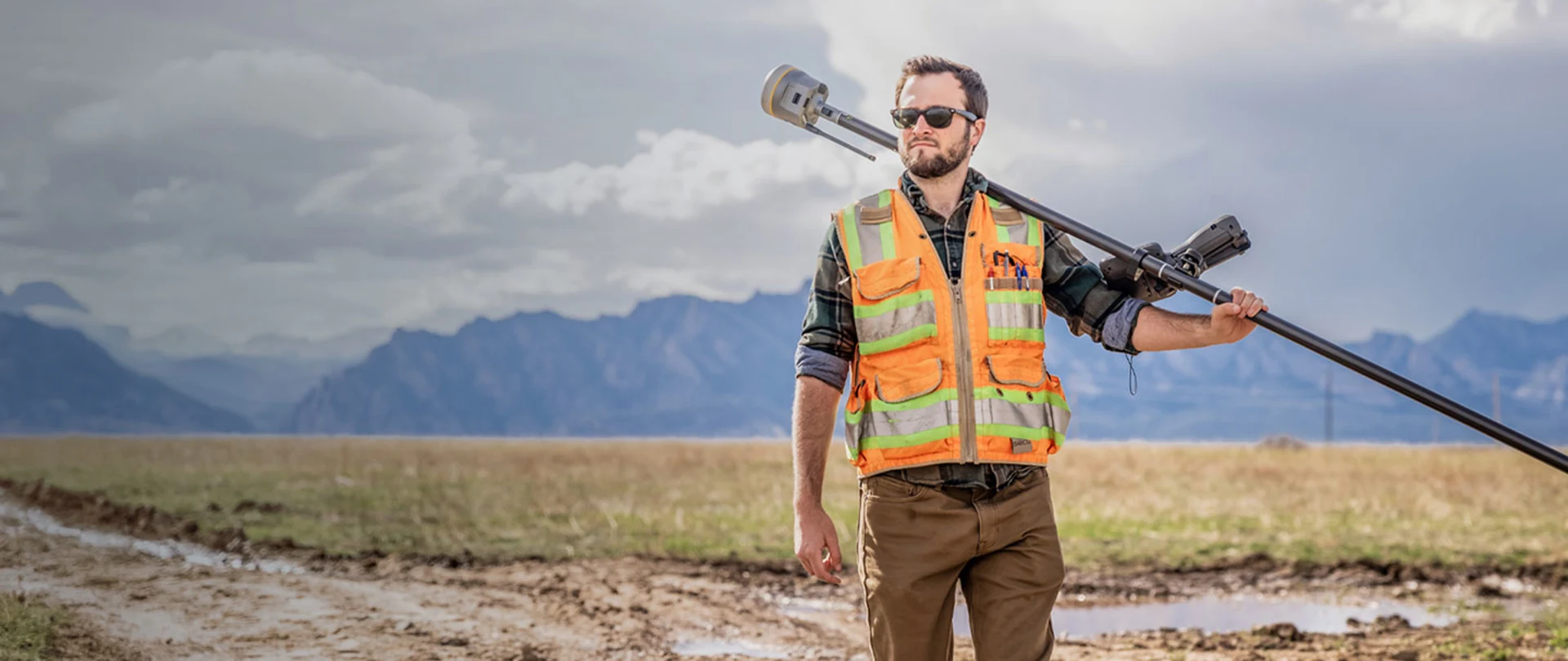 Man on a mountain plain carrying a Trimble receiver