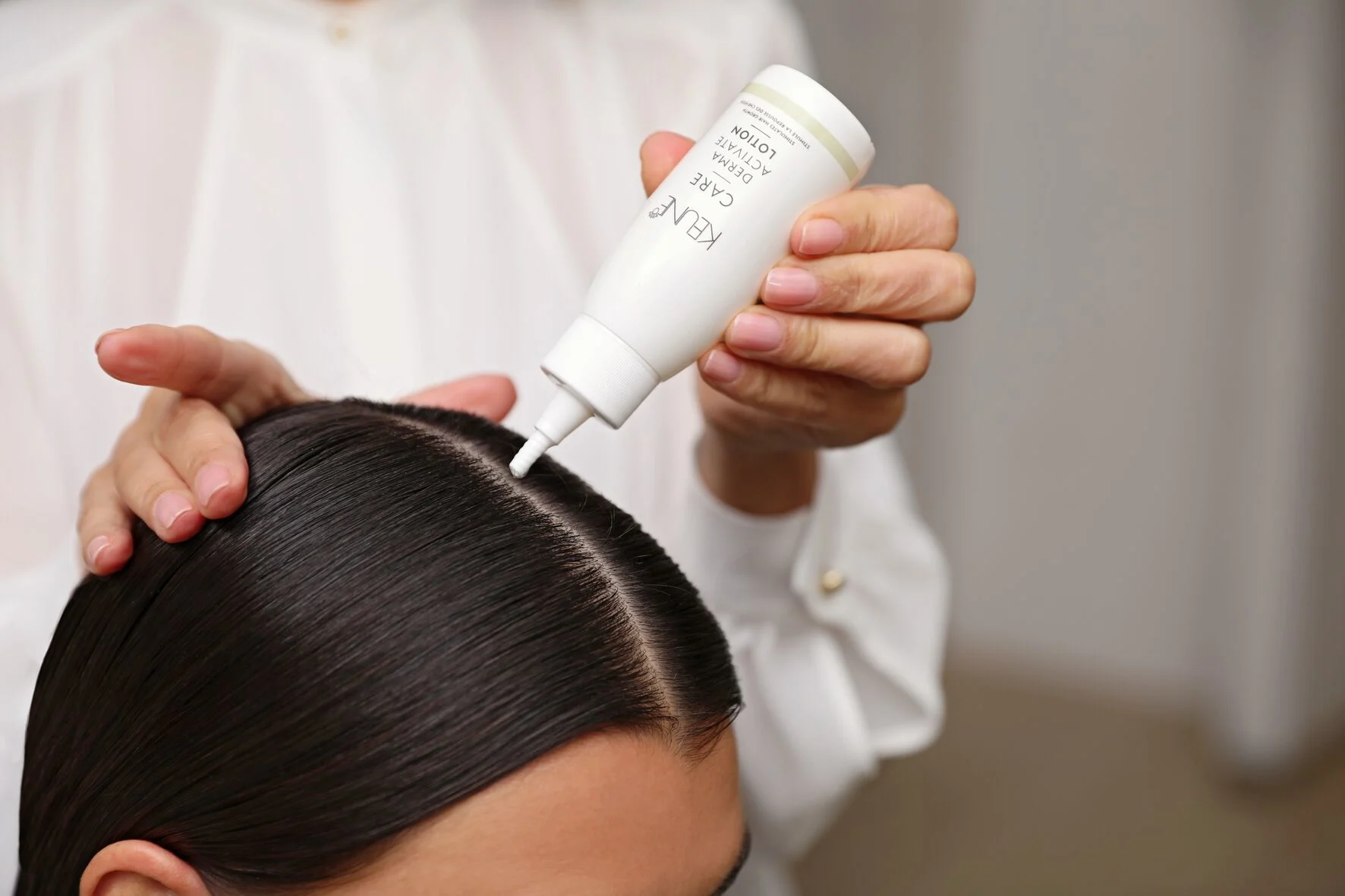 Image of hairstylist using Keune Care Derma Activate Lotion