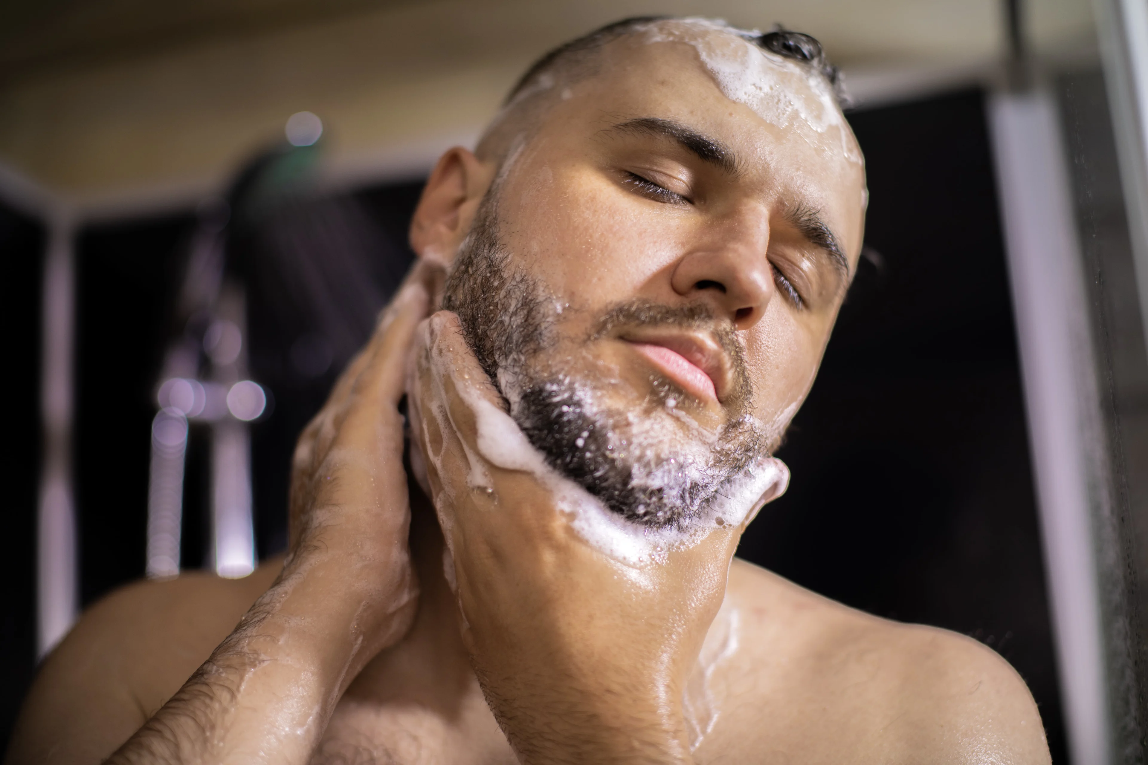 Foto van man die zijn baard wast