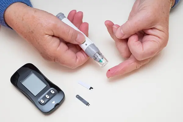 A person tests their blood sugar levels with a blood glucose monitor.